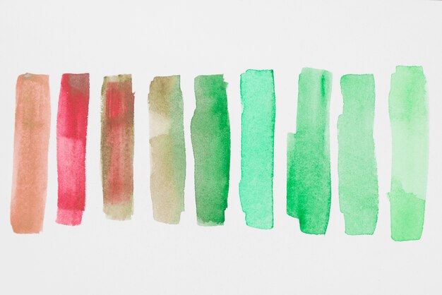 Row of green and red paints on white paper