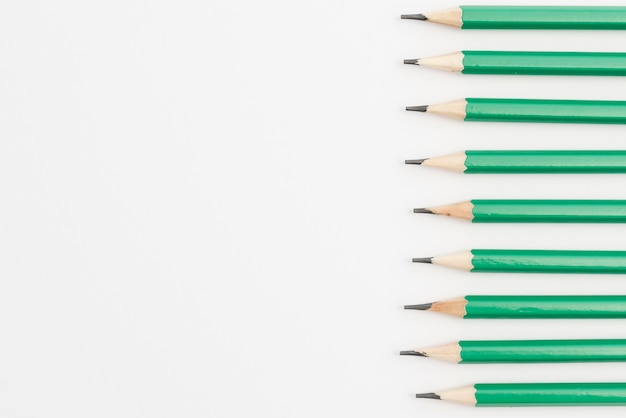 Row of green sharp pencils on white background