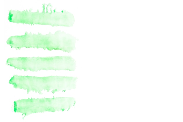 Row of green watercolor brush strokes on white background