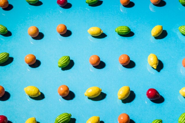 Row of gummy fruits shaped on blue background