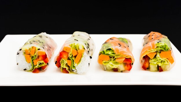 Row of healthy spring rolls on plate