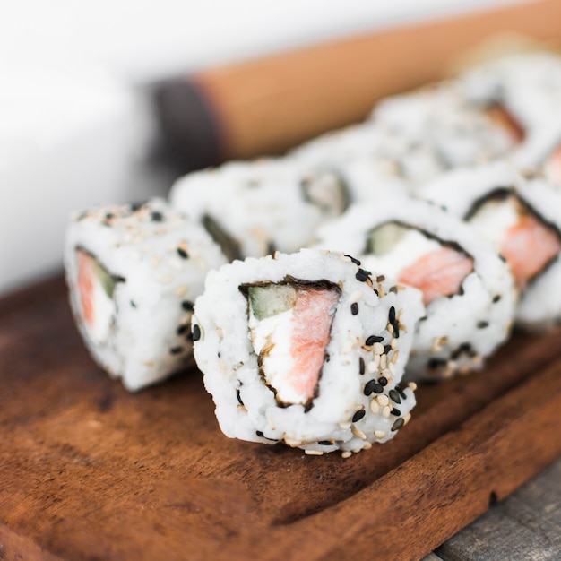 Row of homemade sushi on wooden tray