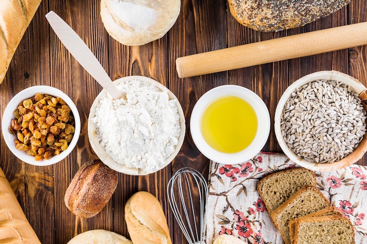 Free Photo row of ingredients with homemade breads on wood table