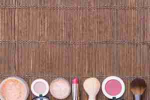 Free photo row of makeup brush; blusher; loose powder on placemat