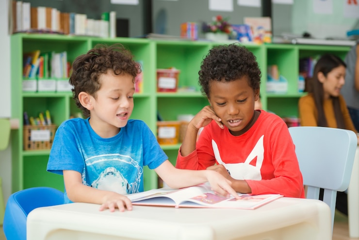 Free Photo row of multiethnic elementary students reading book in classroom. vintage effect style pictures.