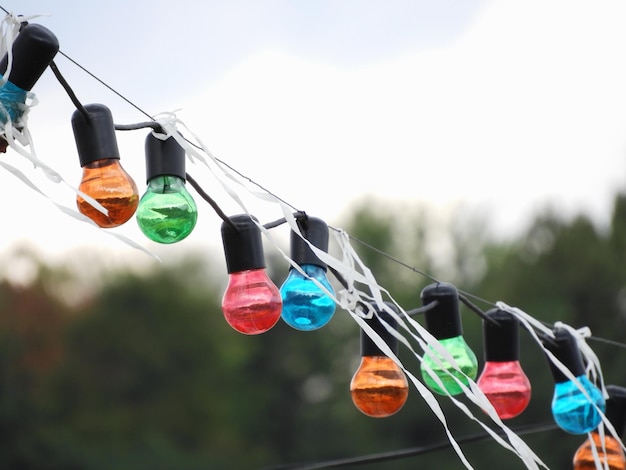 Бесплатное фото Ряд разноцветных лампочек висит на веревке