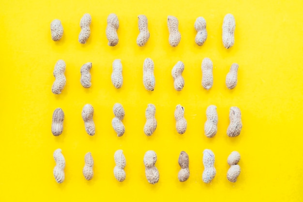 Row of peanuts shell on yellow background
