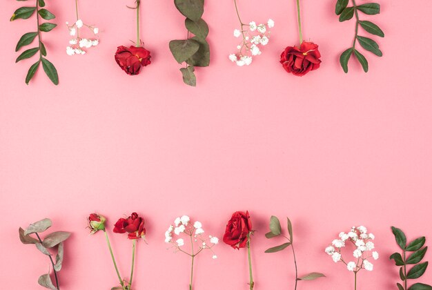 Row of rose; baby's breath; and leafs arranged over peach backdrop