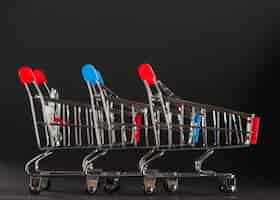 Free photo row of shopping trolleys with red and blue handles