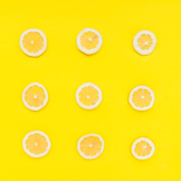 Row of sliced citrus fruits on yellow background