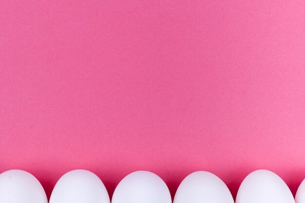 핑크 테이블에 흰 계란의 행