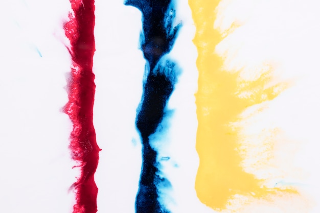 Free photo row of yellow; blue and red color splash isolated over white background