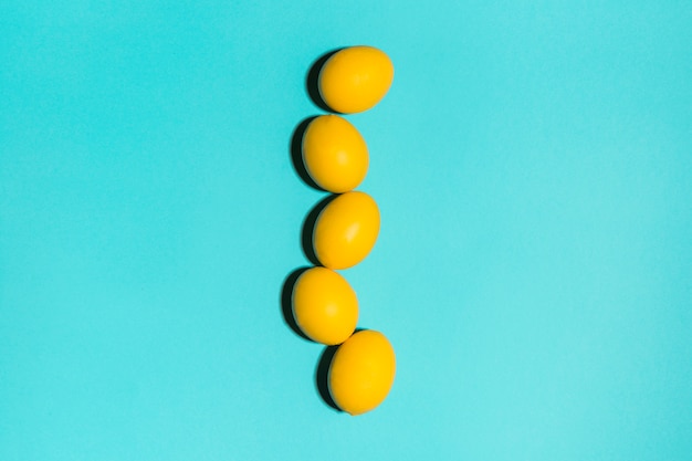 Row of yellow Easter eggs on table