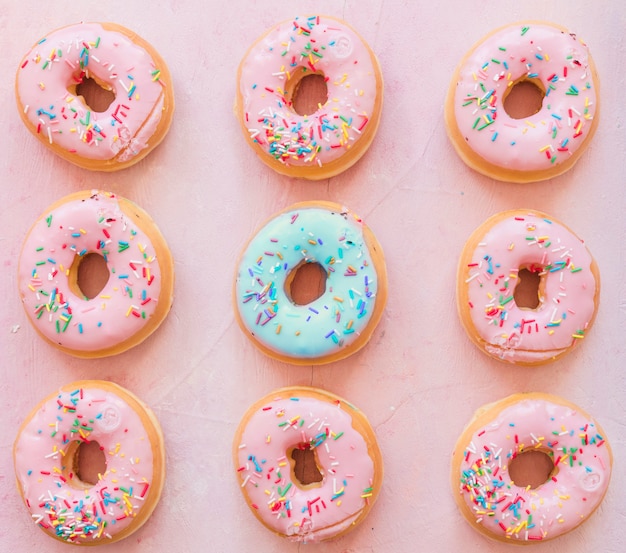 Free photo rows of donuts on pink background