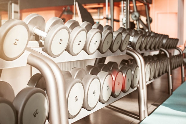 Rows of dumbbells in the gym with hign contrast and monochrome color tone