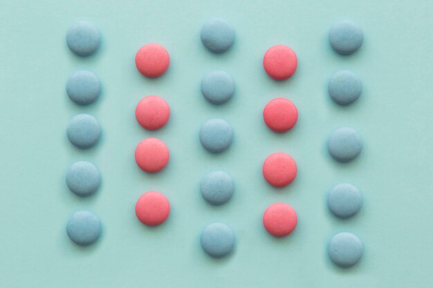 Rows of pink and blue candies on green background