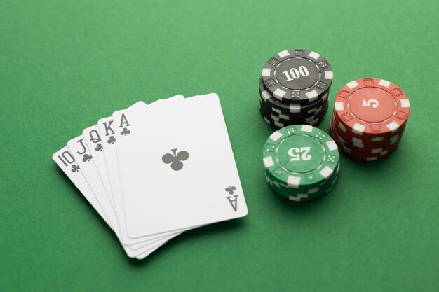 Royal flush and casino tokens on green background