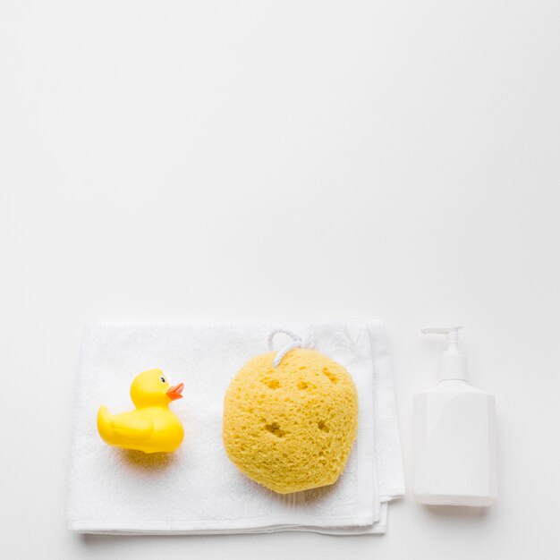 Rubber duck and sponge on towel