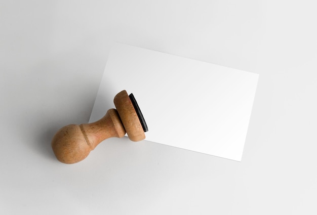 Foto gratuita timbro di gomma con la carta sopra la superficie bianca