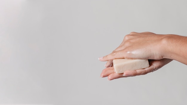 Rubbing hands with block of soap copy space side view