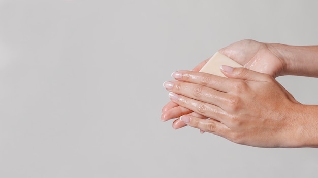 Free photo rubbing hands with block of soap copy space