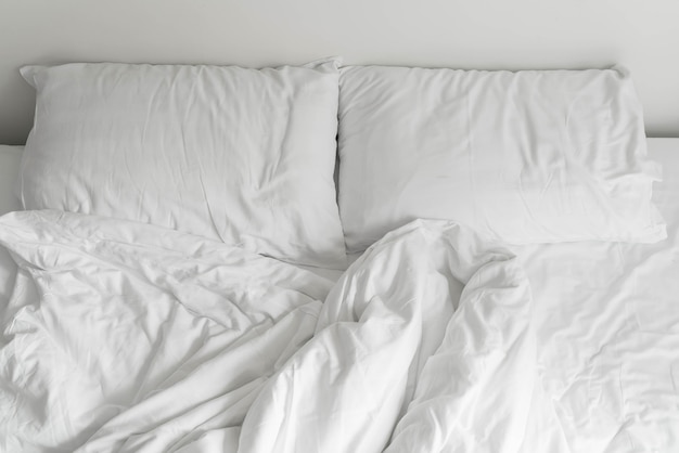 Foto gratuita letto rovinato con decorazione cuscino bianco disordinato in camera da letto