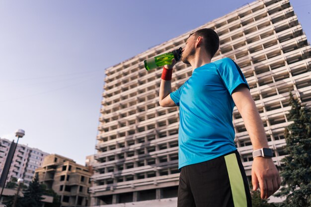 Runner drinking water during a break in the city