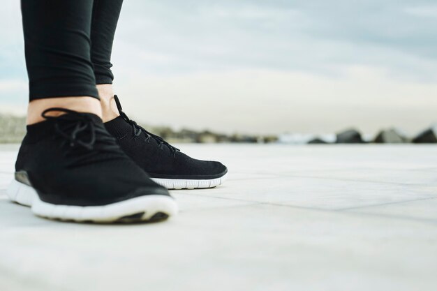 Runner man's feet running on road closeup on shoe