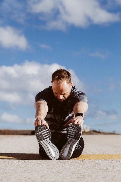 Runner stretching his legs against sky