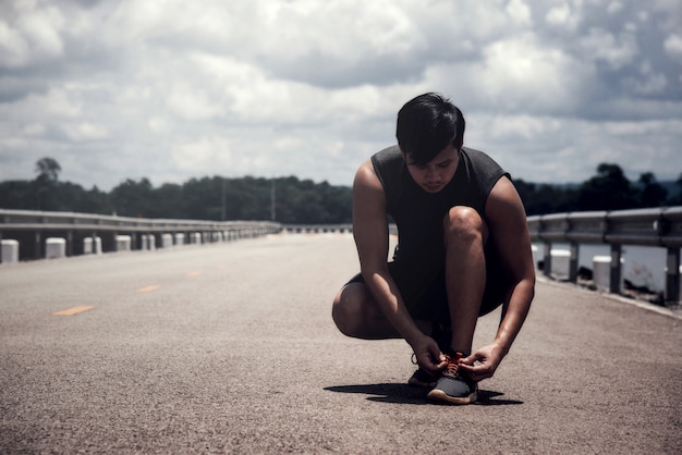 Il corridore che lega le scarpe da jogging