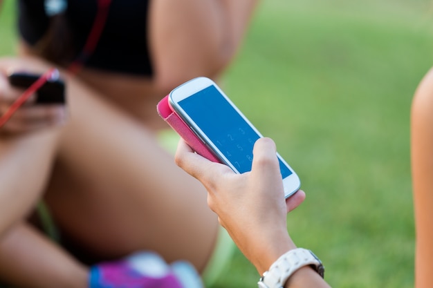 Esecuzione di ragazze divertirsi nel parco con il cellulare.