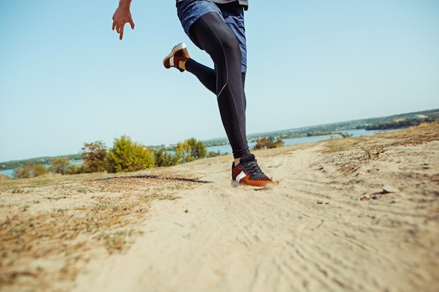 Running sport. Man runner sprinting outdoor in scenic nature. Fit muscular male athlete training trail running for marathon run.