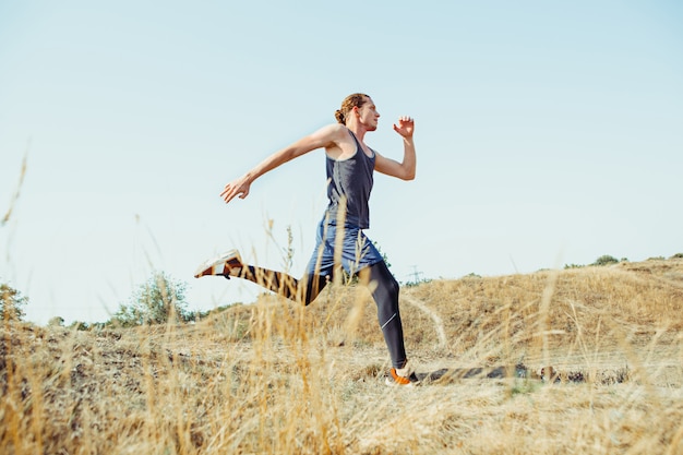 Running sport. Man runner sprinting outdoor in scenic nature. Fit muscular male athlete training trail running for marathon run.