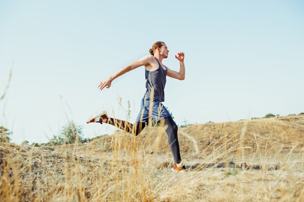 スポーツを実行しています。風光明媚な自然の中で屋外全力疾走の男性ランナー。マラソンランニングに適した筋肉質の男性アスリートトレーニングトレイルを装着します。