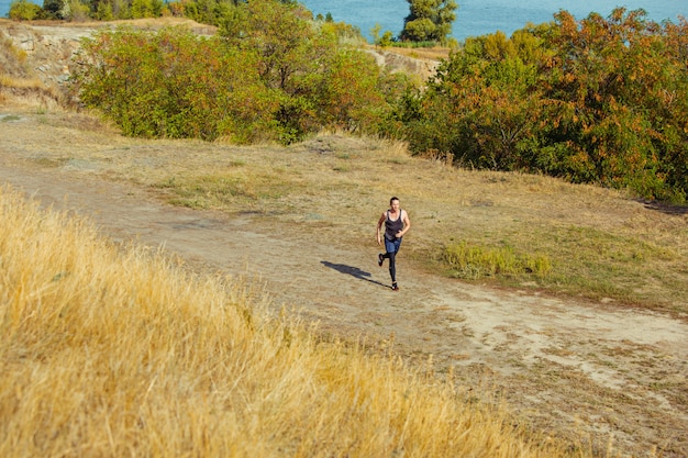 Running sport. Man runner sprinting outdoor in scenic nature.