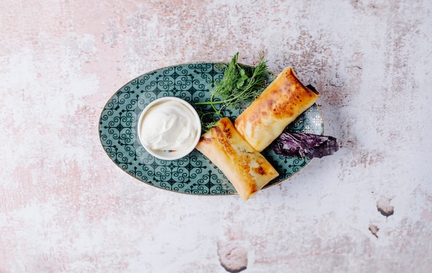 Free photo russian apetizer blinchik in crepes with herbs and yogurt.