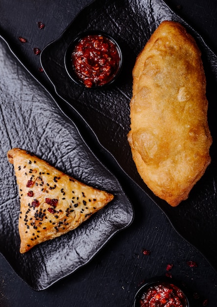 Russian pirojki varieties on a black platter.