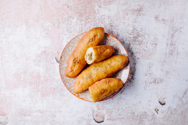 접시 안에 고기 먹거리와 러시아 pirojki입니다.