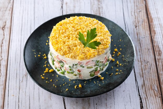 Russian salad or Olivier salad for Christmas dinner on wooden table