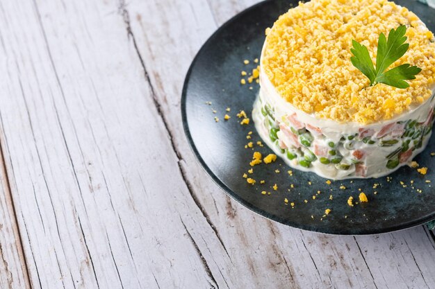 Russian salad or Olivier salad for Christmas dinner on wooden table