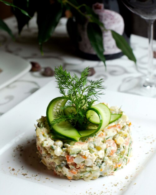 Russian salad with cucumber slices