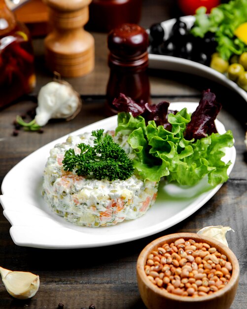 Russian salad with herbs on top