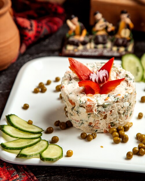 Russian salad with side beans and sliced cucumber _