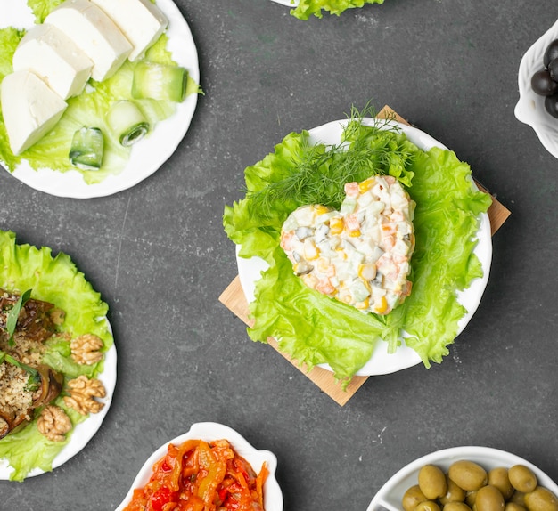 Free photo russian stolichni salad in heart shape on a lettuce. top view