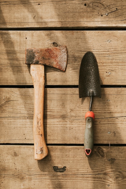 Rustic axe by trowel flatlay on a wooden background