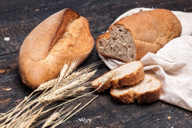 Rustic bread on wood table. Dark wooden background