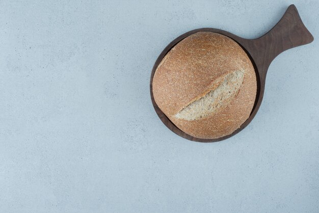 Rye bread roll on wooden board