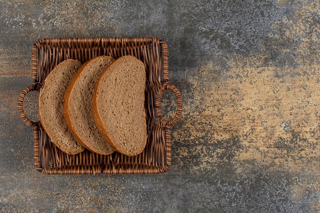 Rye bread slices in wooden basket.