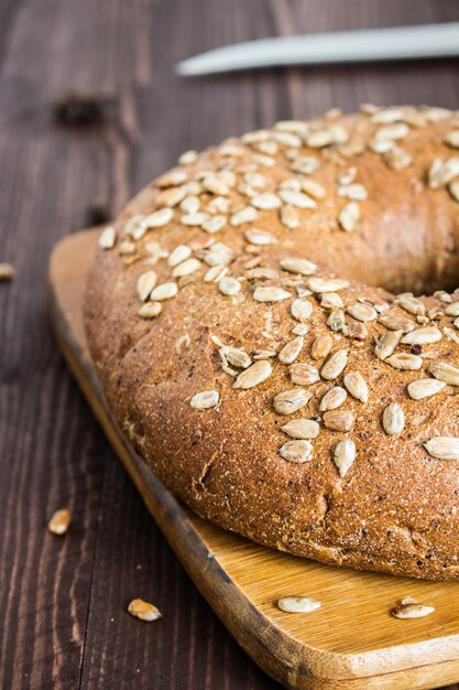 Rye bread with sunflower seeds on wood board