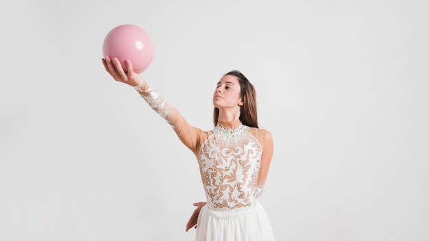 Rythmic gymnast posing with the ball